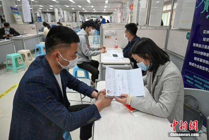 4月14日，招聘者在查看求職者簡歷。<a target='_blank'  data-cke-saved- >中新社</a>記者 王剛 攝