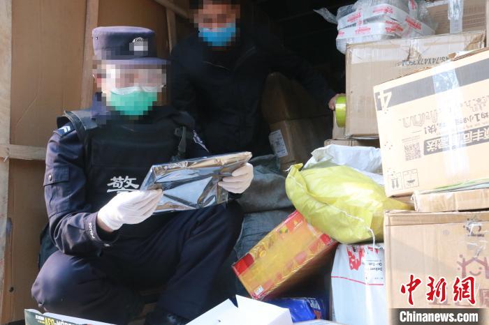 圖為勐康邊檢站民警在對(duì)快遞運(yùn)輸車輛進(jìn)行例行檢查?！钐?攝