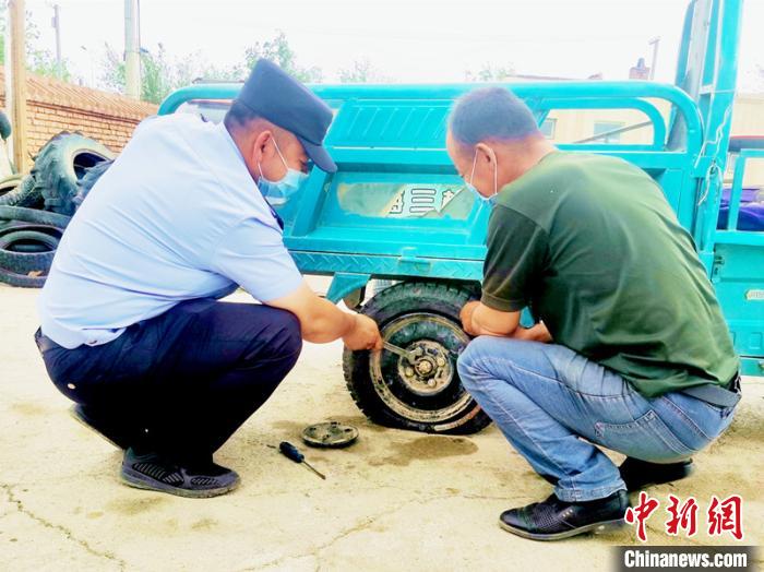 賽旦與民警共同維修三輪摩托車?！∫懒窘?攝