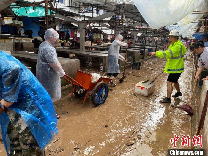 圖為7月26日，暴雨引發(fā)的洪水過(guò)境后，重慶萬(wàn)州區(qū)分水鎮(zhèn)政府干部職工及志愿者清掃淤泥和垃圾?！　≈貞c萬(wàn)州區(qū)委宣傳部供圖 攝