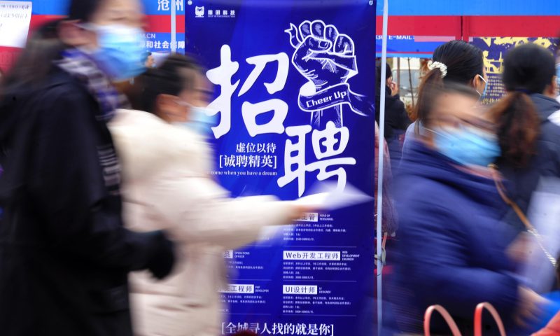 求職者從一家招聘企業(yè)的廣告牌前走過。新華社發(fā)（苑立偉 攝）