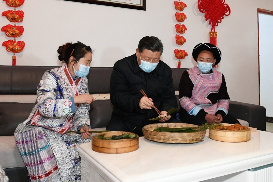 2021年2月3日下午，習(xí)近平在貴州畢節(jié)市黔西縣新仁苗族鄉(xiāng)化屋村苗族村民趙玉學(xué)家，同一家人邊聊家常邊制作當(dāng)?shù)貍鹘y(tǒng)節(jié)日食品黃粑。新華社記者 李學(xué)仁 攝